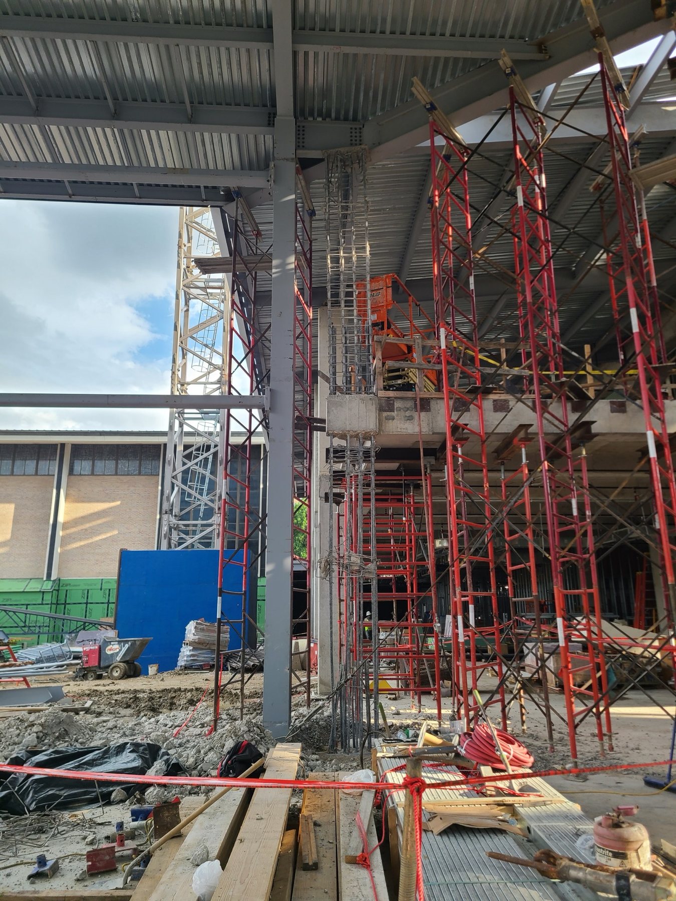 Shoring towers around a column being rebuilt, with the reinforcing cage continuing above the existing stub